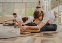 요즘직장인들이 요가를 해야 하는 이유 a group of people doing yoga in a room