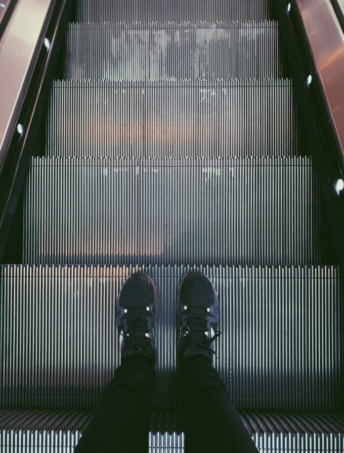 person standing on escalator