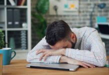 만성피로, ‘휴식 습관’이 해답… 일상에서 실천하는 에너지 회복법 a man sitting at a desk with his head in his hands