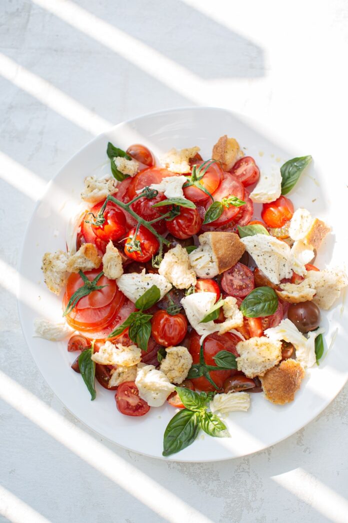 Photo by Luisa Brimble sliced tomato and green leaf vegetable on white ceramic plate