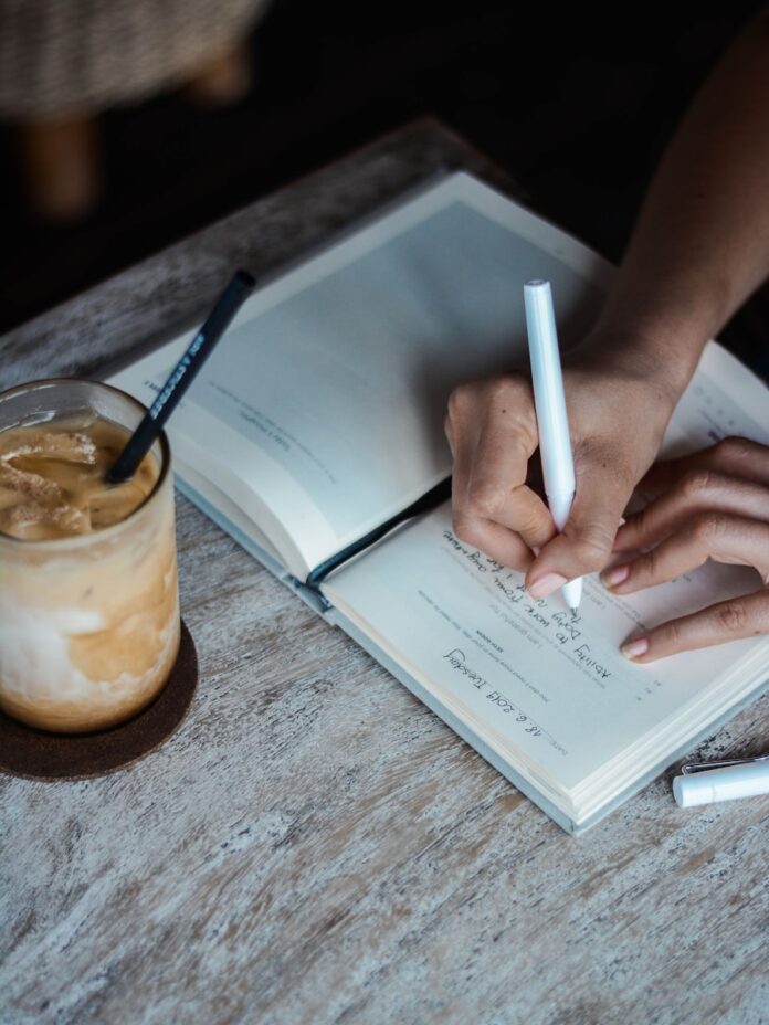 Photo by Prophsee Journals person writing on book