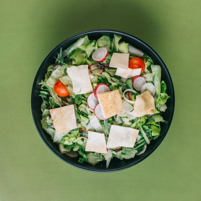 Photo by sina piryae green salad on a black bowl
