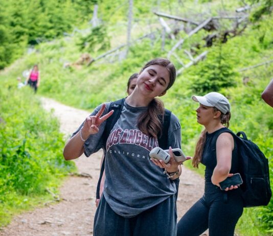 현대인을 위한 적정 걷기 습관, 건강도 시간도 잡는다 Young woman makes peace sign on a forest trail